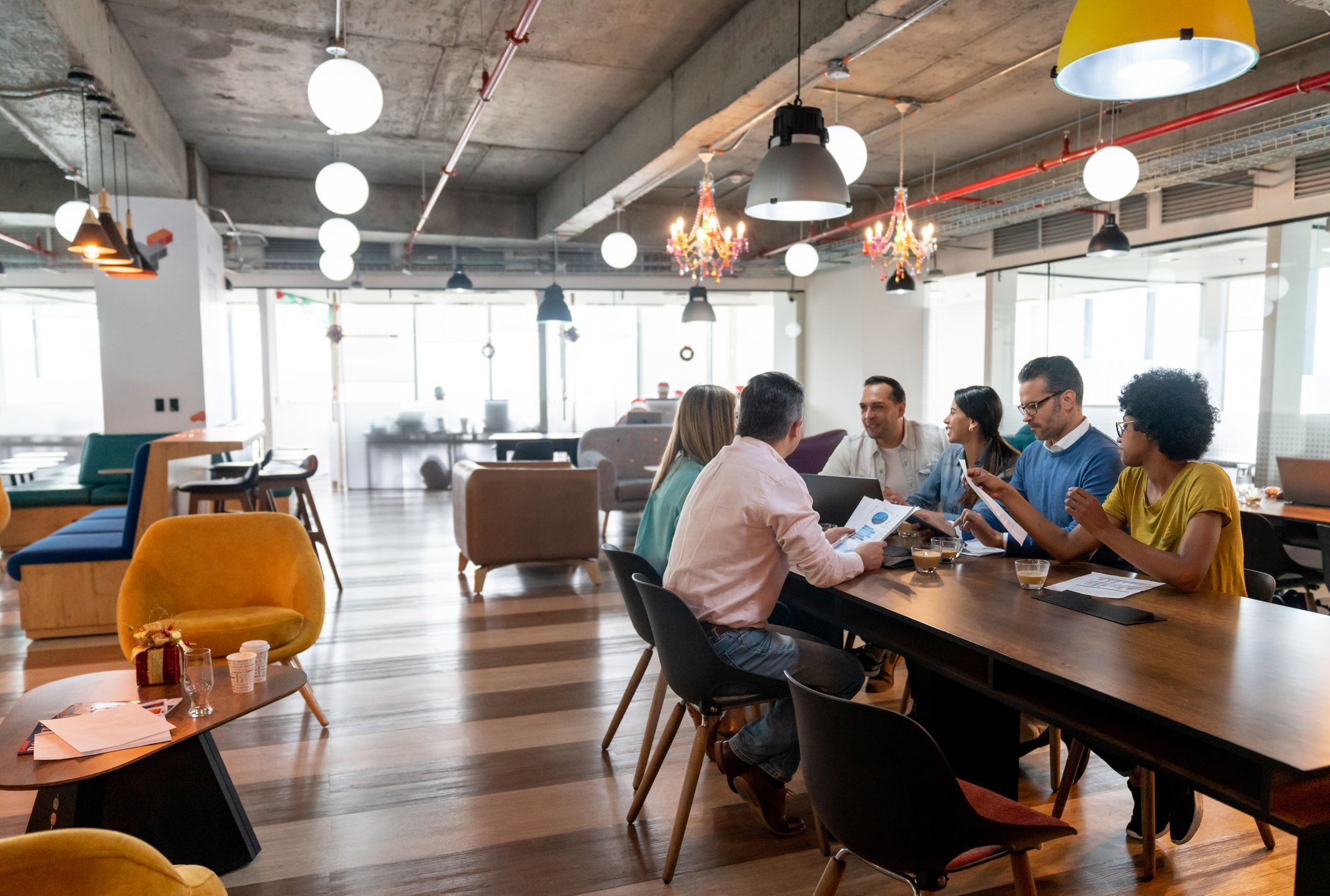 Multi ethnic group of professionals at a coworking office in a meeting discussing something looking focused