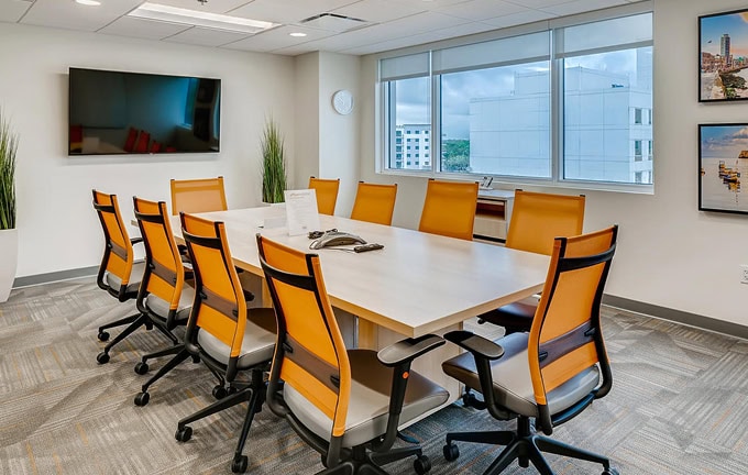 Office Evolution franchising meeting room in Spain with modern furniture and large windows.